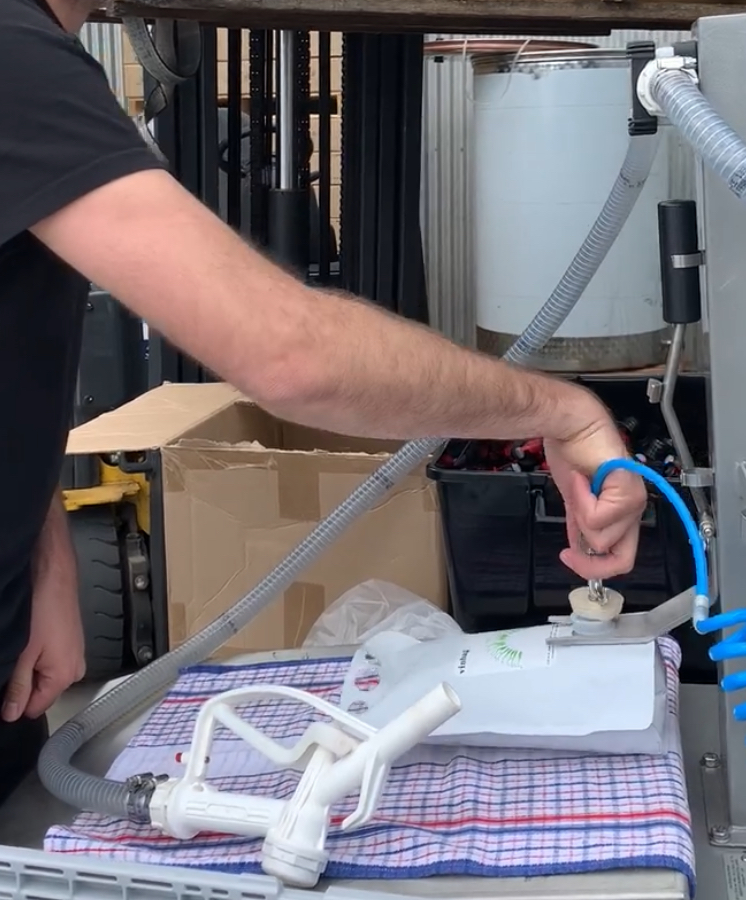 Gravity filling machine, wine pouches and taps