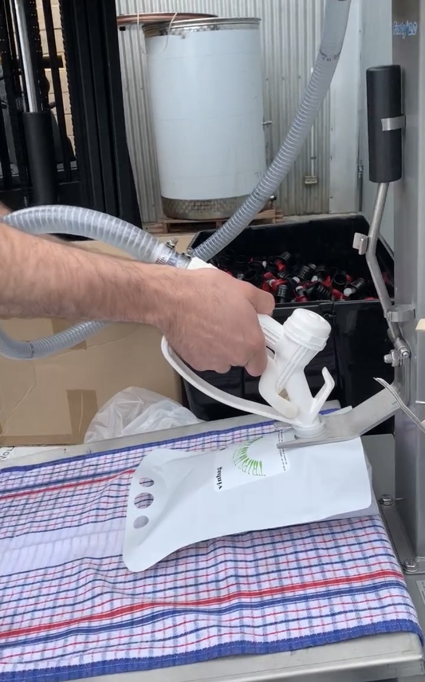 Gravity filling machine, wine pouches and taps